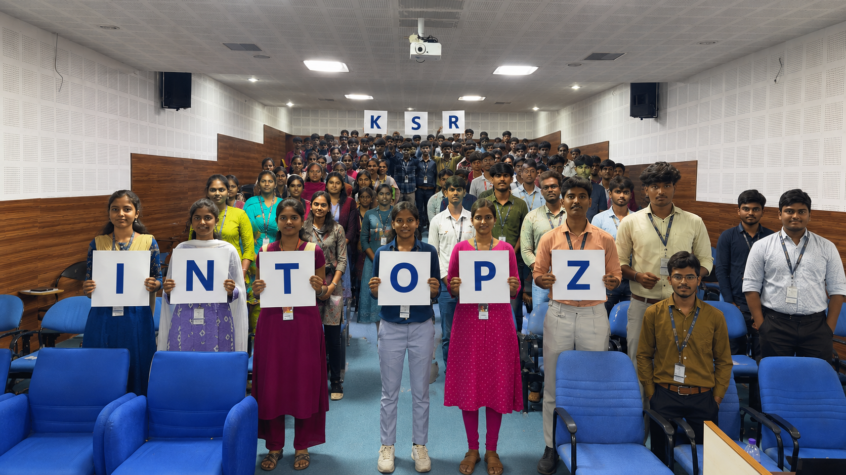 KSR students holding INTOPZ letters in an auditorium