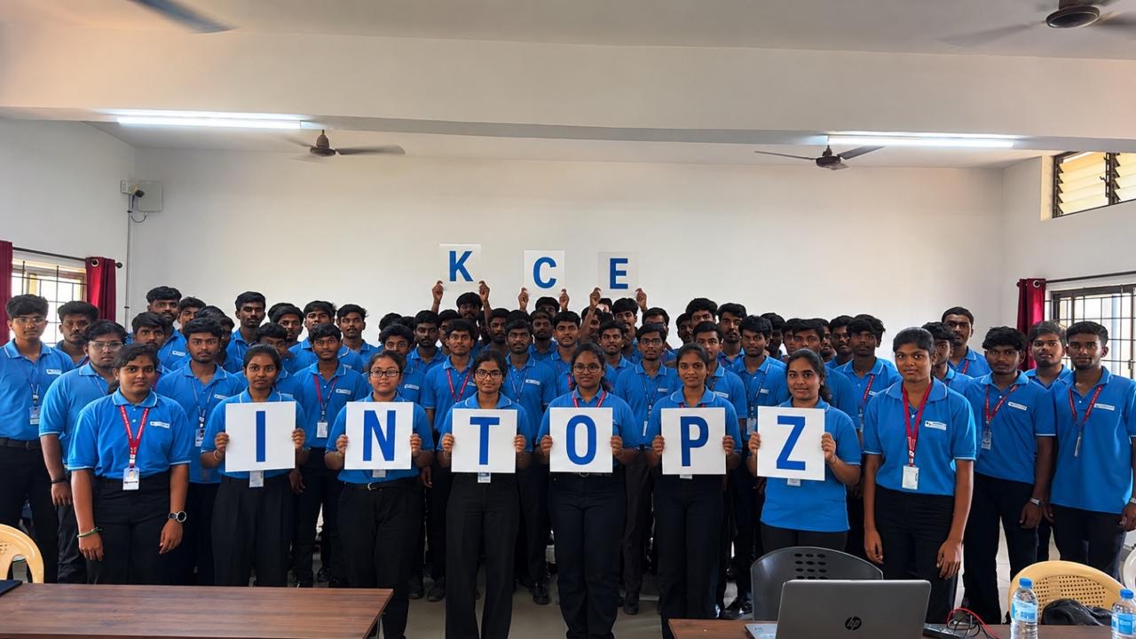 Students in blue uniforms holding KCE and INTOPZ letter placards